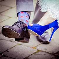 Bride and groom showing of their shoes.
