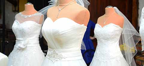 Weddign dresses displayed in store window.